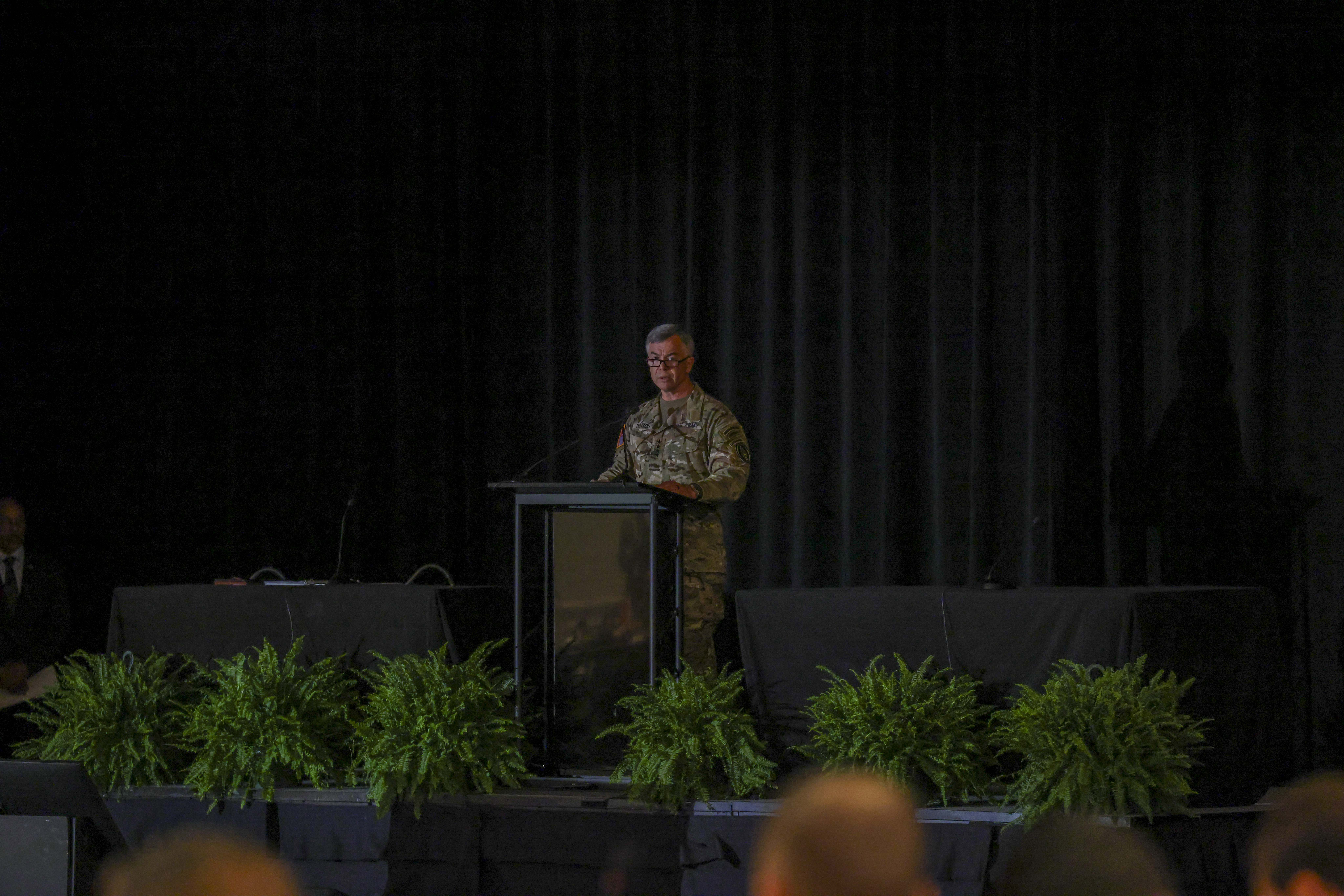 Man standing at a podium addressing an audience.