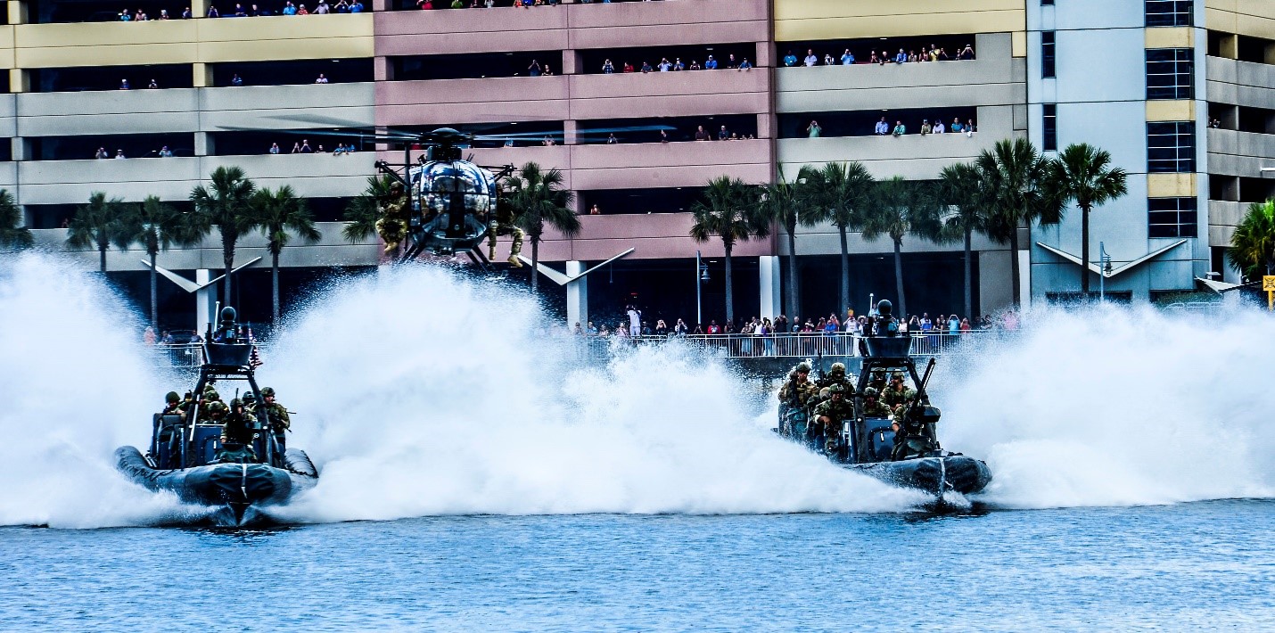 Two rigid-hulled inflatable boats and a MH-6 Little Bird