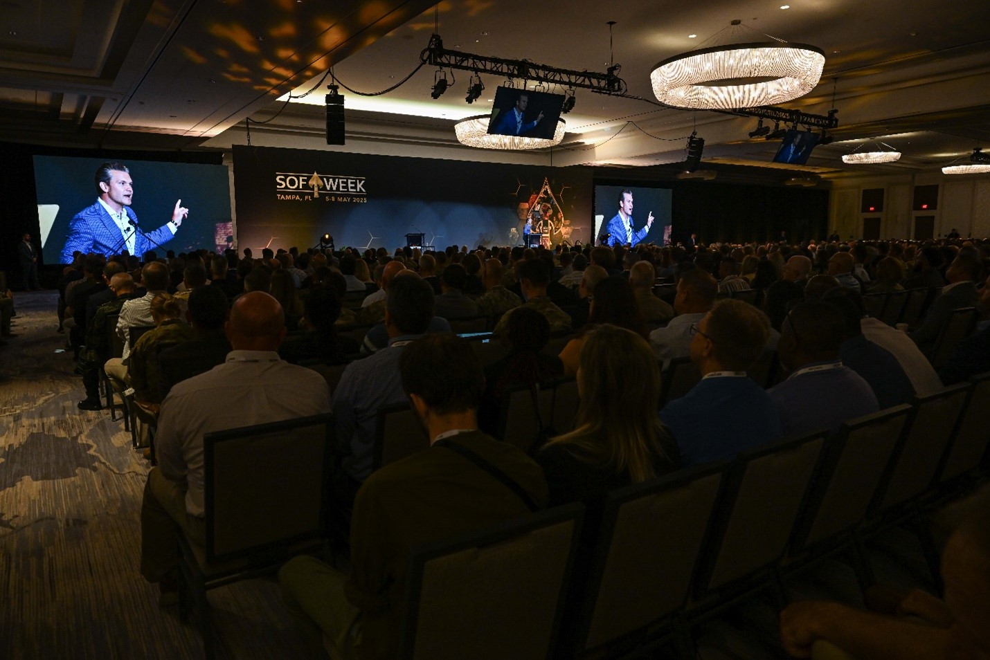 Audience watching man speak on stage.
