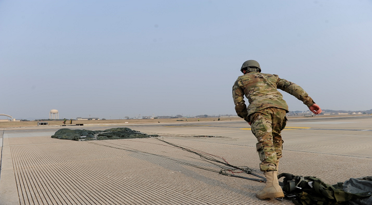 Paratrooper running to retrieve his parachute.
